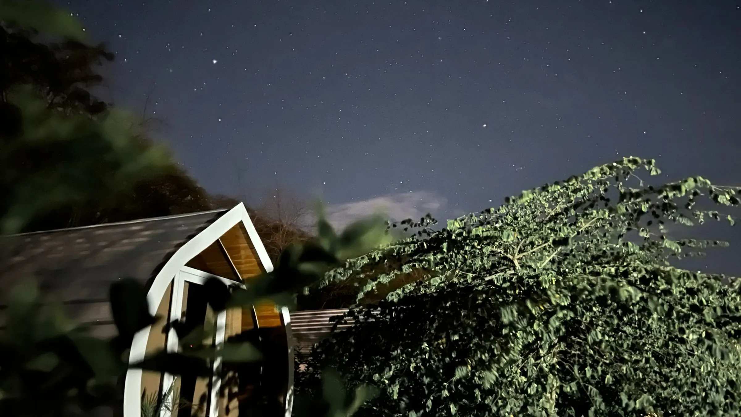A capsule cabin at night under a sky full of stars