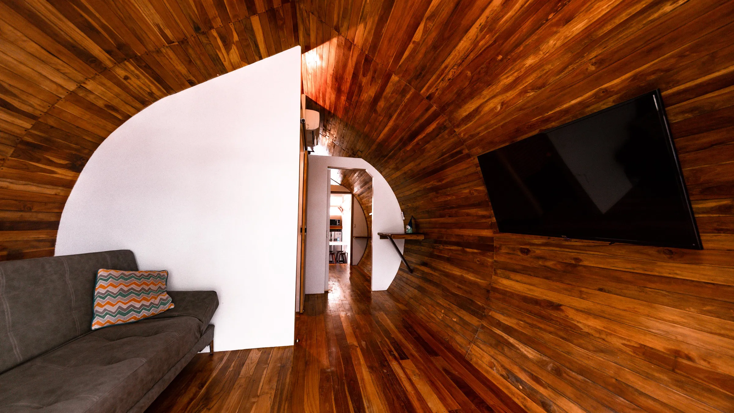 The teak-lined living room of a capsule cabin